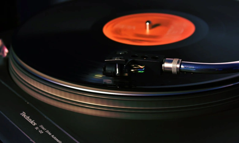 Gramofon s jehlou na černém vinylu.