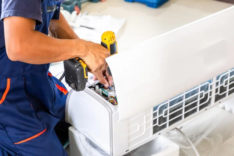 Technik odšrouvává přední panel klimatizace elektrickým šroubováčem.