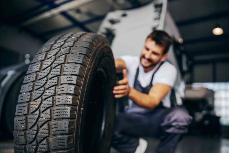 Mechanik ukazuje směr závitu pneumatiky v dílně