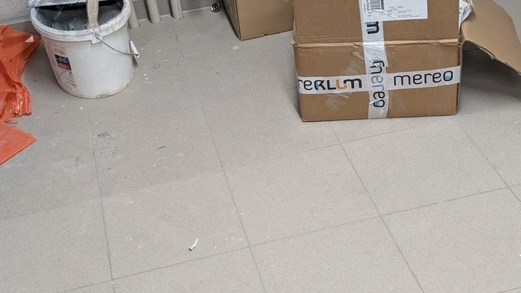 Dlaždice na podlaze s krabicemi v pozadí