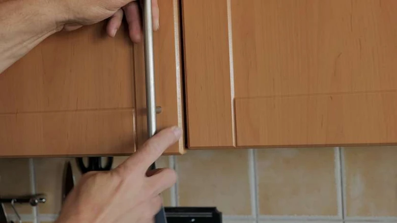 Ruční úprava pantu na dvířku kuchyňské skříňové linky.