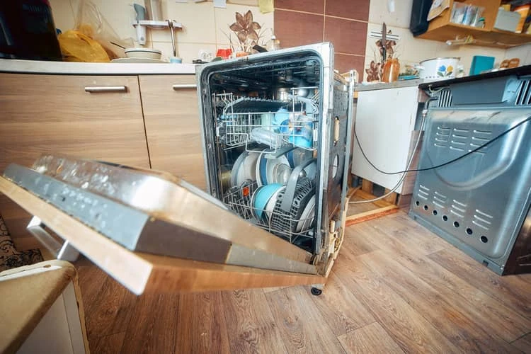 Otevřená myčka s nádobím uvnitř v kuchyni