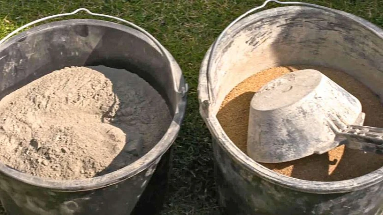 Dva kbelíky s betonem a pískem pro výrobu zahradních figurek.