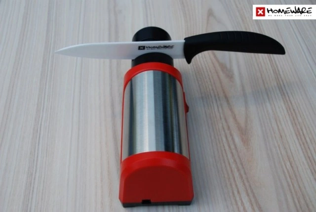 Červený brousek pro keramické nože s vloženým nůžkem.