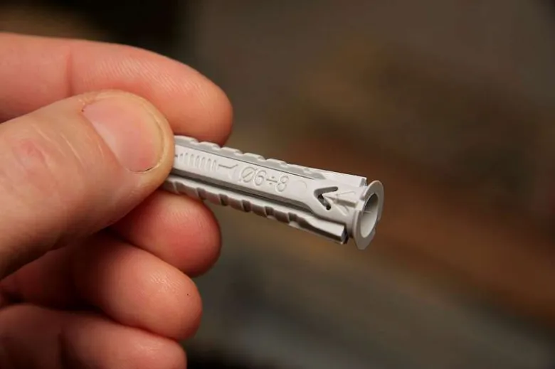 Bílá plastová hmoždinka s označením pro šroub o průměru 8 mm.