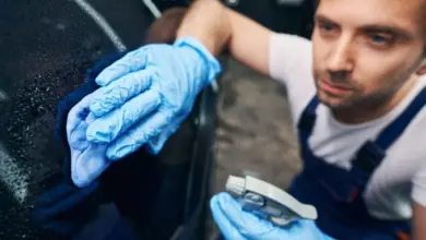 Muž čistí povrch vozu před lakováním pomocí rozpouštědla.