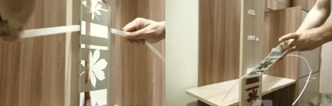 Ruční odlepení lepicí pásky z dřevěného dvířka skříňky.