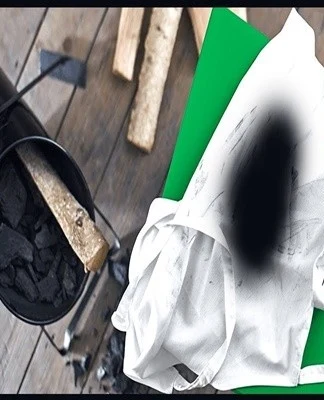 Kbelík s uhlím a špinavé bílé plátno pokryté sazí.