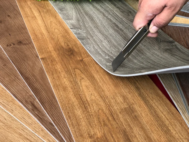 Ruka řezá laminátovou podlahu nožem pro přesné vyřezání