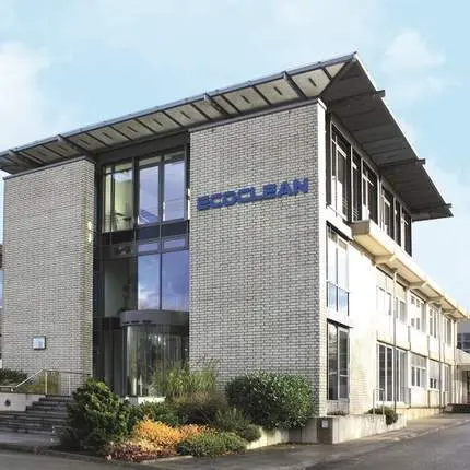 Vnější pohled na budovu firmy Ecoclean s logem u vstupu.