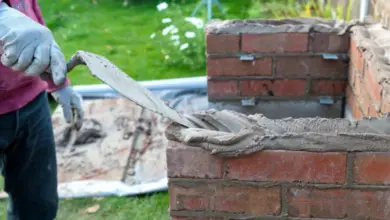 Stavební práce s cihlami pomocí špachtle na zahradě.