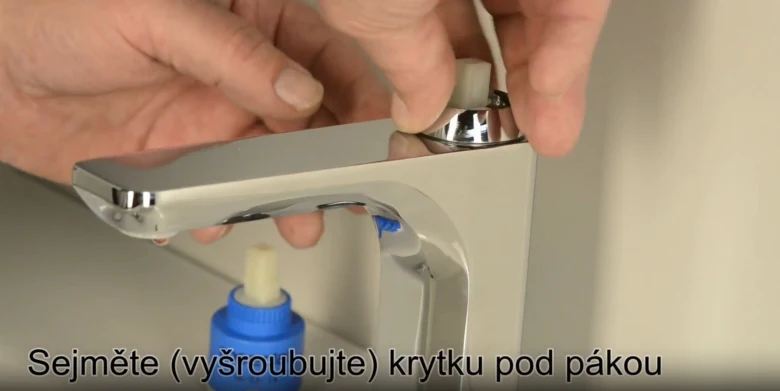 Ručník odšrouvuje krytku pod pákou kohoutku.