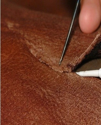 Rozmazání lepidla na kůži pomocí nástroje pro spojování materiálu.