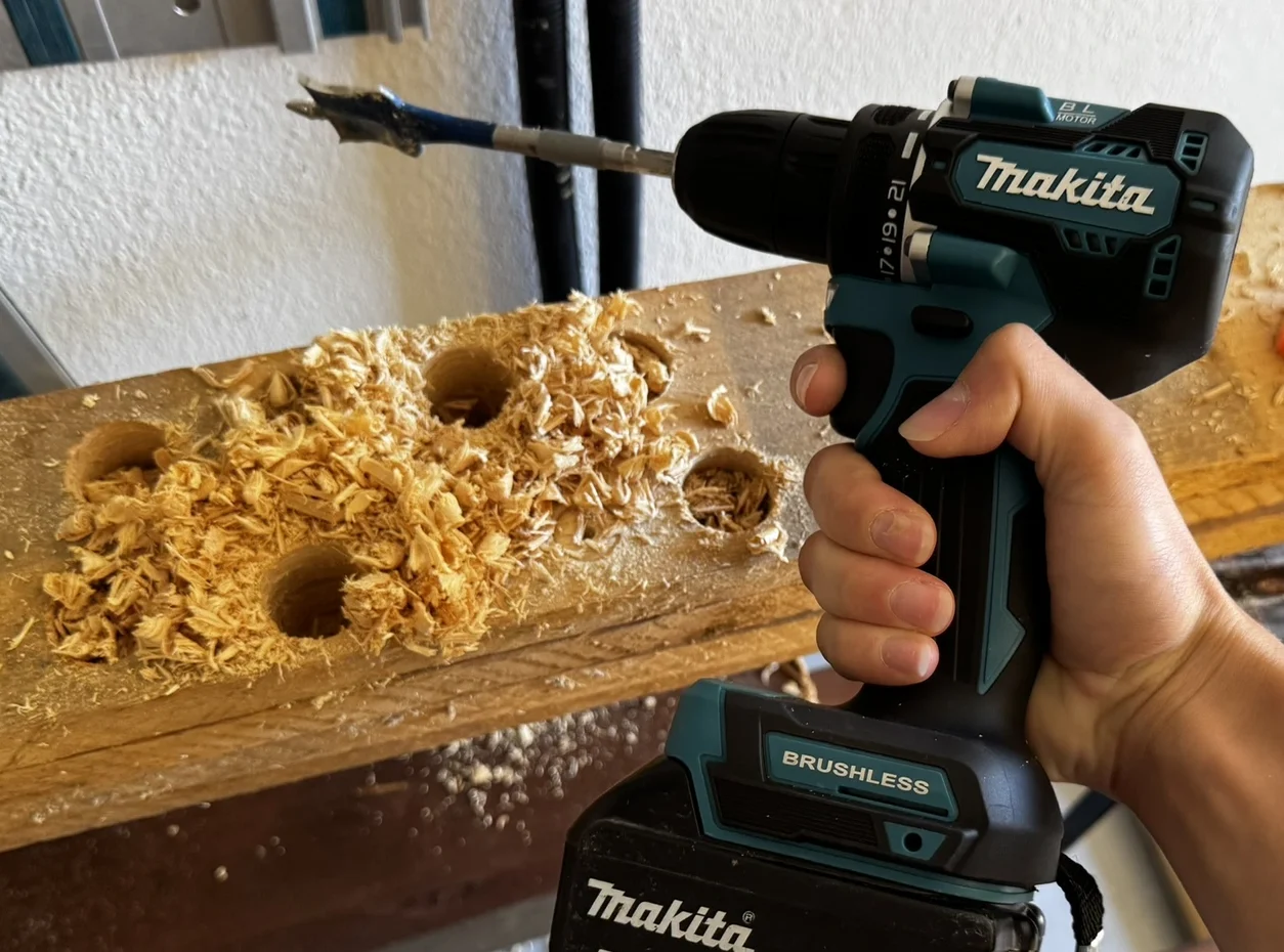 Přímý pohled na originální šroubovák značky Makita při práci s dřevem.