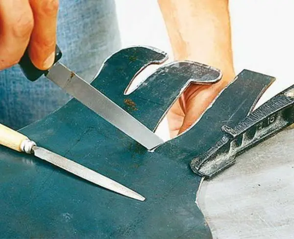 Ruční výřez vzoru z materiálu při šití.