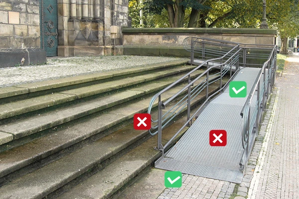 Rampa pro invalidy vedle schodů s porušenými normami.