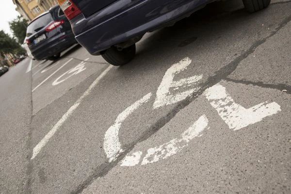 Značení parkovacího místa pro osoby se zdravotním postižením na asfaltu.