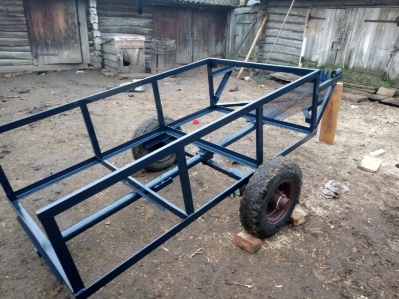 Modrý kovový rám přívěsu pro traktor s dvěma koly.