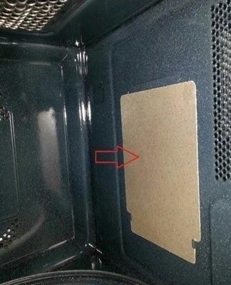 Vnitřek mikrovlnné trouby s ukazovatelem na skládací desku.