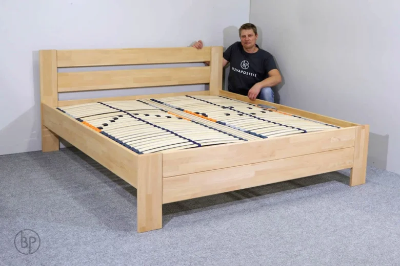 Dřevěná postel s nosníky ukazuje sestavený rám.