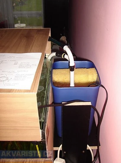 Domácí filtr pro studniční vodu s žlutou houbou a hadicemi.