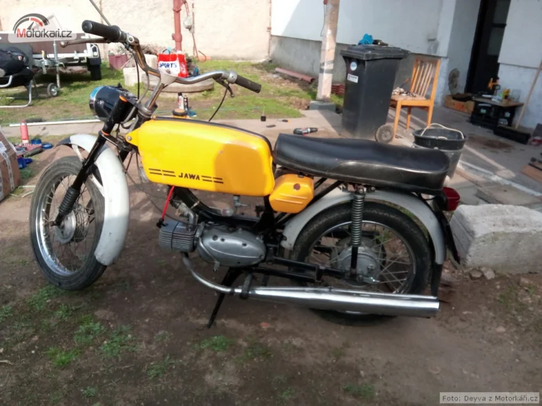 Žlutá motorka s chromovaným výfukem a motoru.