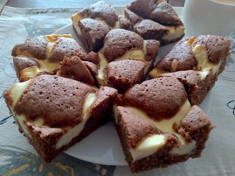 Čokoládové cheesecake tyčinky s bílým náplní na talíři.