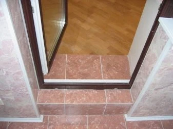 Hotový dlažbový práh pro vchodové dveře s dřevěným rámem.