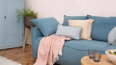 Pastelově modrá obývací místnost s růžovými doplňky.
